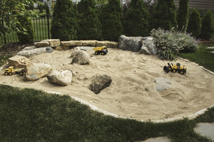 there is a sand pit with toys in it