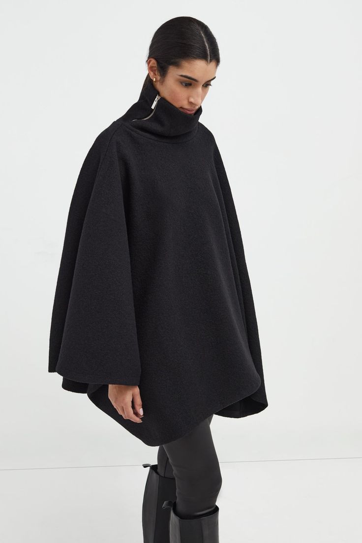 A stylish wool winter cloak, our Avery Cape is the ideal choice for heading out into the cold. Fashioned from Italian virgin wool and offered in fresh neutrals that pair well with any combination of clothing, this women’s wool cape is designed with a loose silhouette. Simple. Elegant. Cozy. Layer her over anything for an instant ready-to-go look. Avery's high collar has a side zipper for style and easy wear. This wool winter cape is lined for added warmth and comfort. | Astrid, in medium grey an Oversized Winter Cape For Work, Long Sleeve Wool Cape For Fall, Chic Winter Wool Cape Coat, Chic Cashmere Cape For Winter, Black Wool Poncho For Winter, Elegant Fall Poncho For Work, Oversized Chic Wool Poncho, Elegant Fall Poncho For Workwear, Elegant Cashmere Winter Cape