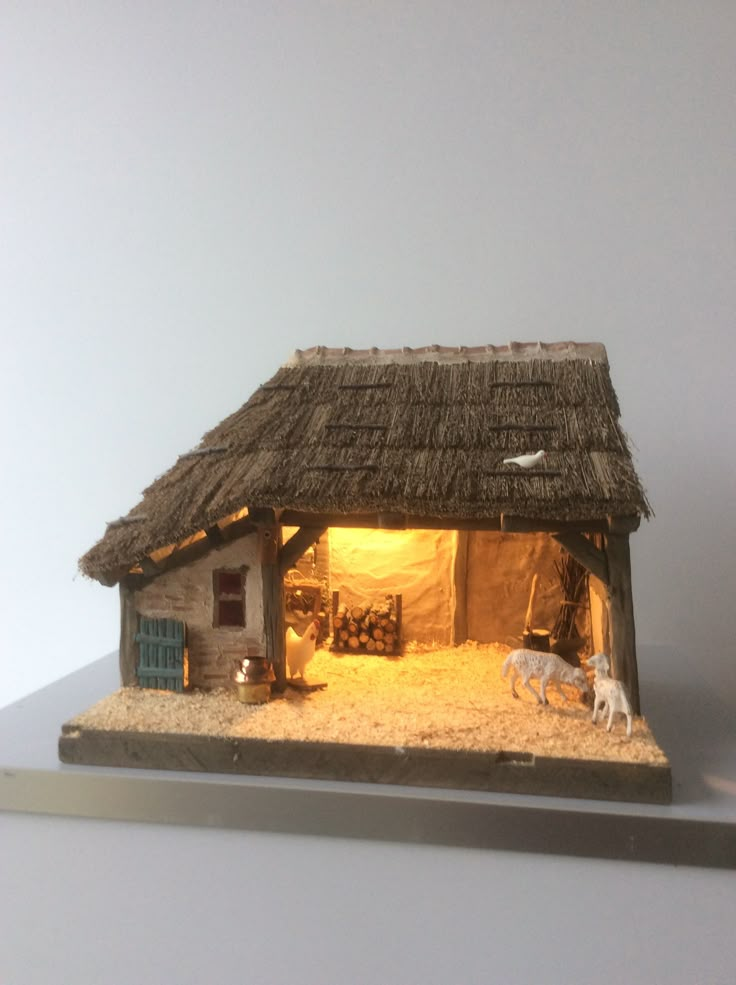 a nativity scene is displayed on a white surface with two figurines in the foreground