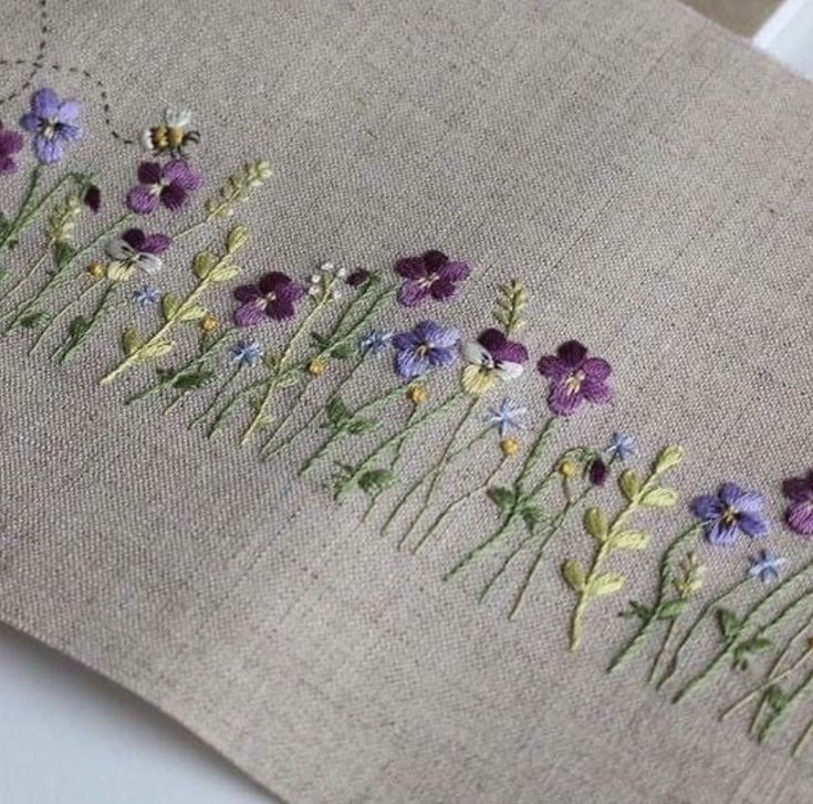 a close up of a piece of cloth with flowers embroidered on the front and back