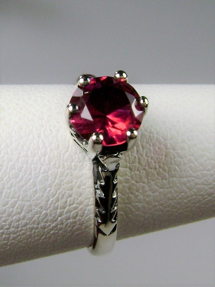 Simulated Red Ruby Ring Wedding #D22 This is a Victorian Era solitaire ring. This lovely sterling silver wedding solitaire has an approximately .5 carat simulated red ruby gemstone. This full cut flawless gemstone is 6mm (1/4") in diameter. The inside of the band is marked 925 for sterling silver. Notice the beautiful crown design of the silver filigree setting and the etched band. This is a lovely rendition of an Antique filigree ring. Classically fashioned, this ring is a vintage wedding style Red Ruby Ring, Antique Filigree, Victorian Wedding, Crown Design, Vintage Style Wedding, Filigree Ring, Ruby Gemstone, Red Ruby, Engraved Items