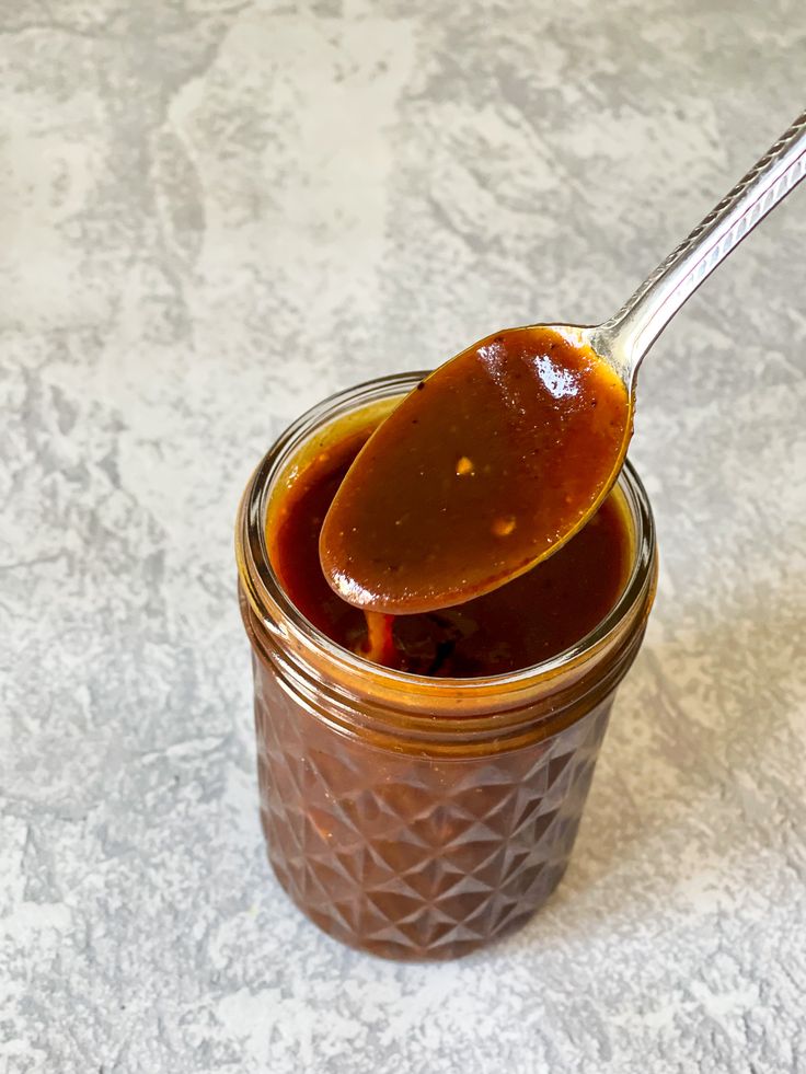 a spoon full of homemade hoisin sauce on top of a jar with the words easy homemade hoisin sauce