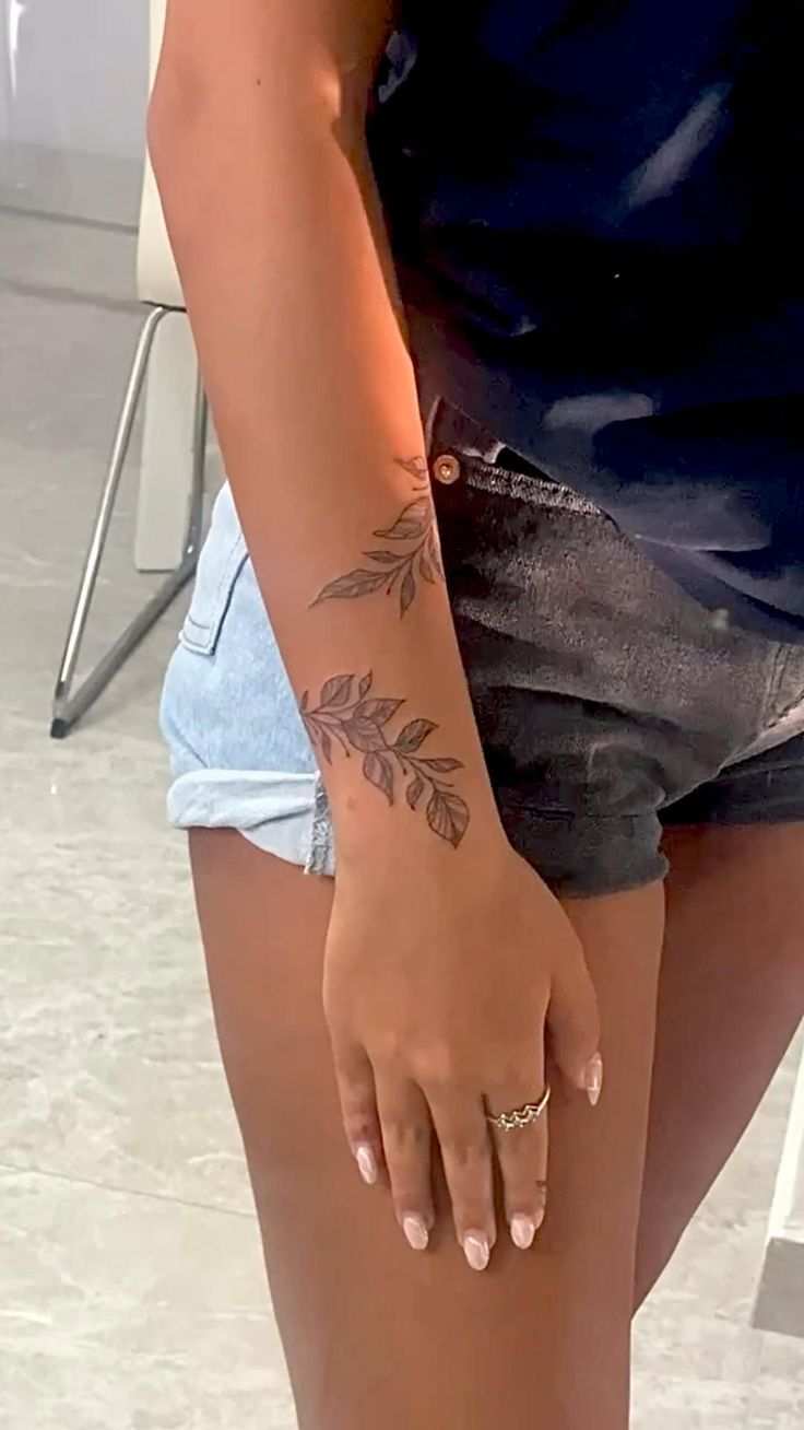 a woman with a tattoo on her left arm and one hand is holding onto the leg of another person