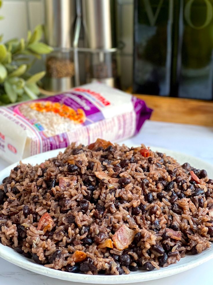 a white plate topped with rice and beans next to a bag of cereal on a table