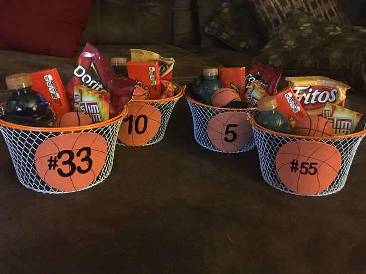 three baskets filled with sports items on top of a couch