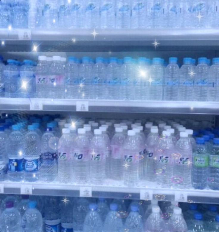 several rows of bottled water on shelves in a store