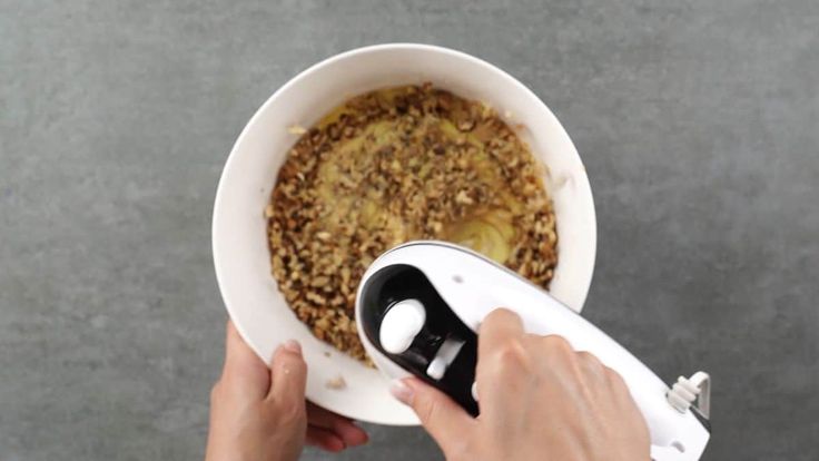 a person using an electric hand mixer to make a bowl of cereal in a bowl