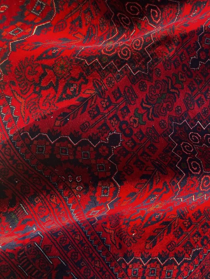 a red and black area rug with designs on it