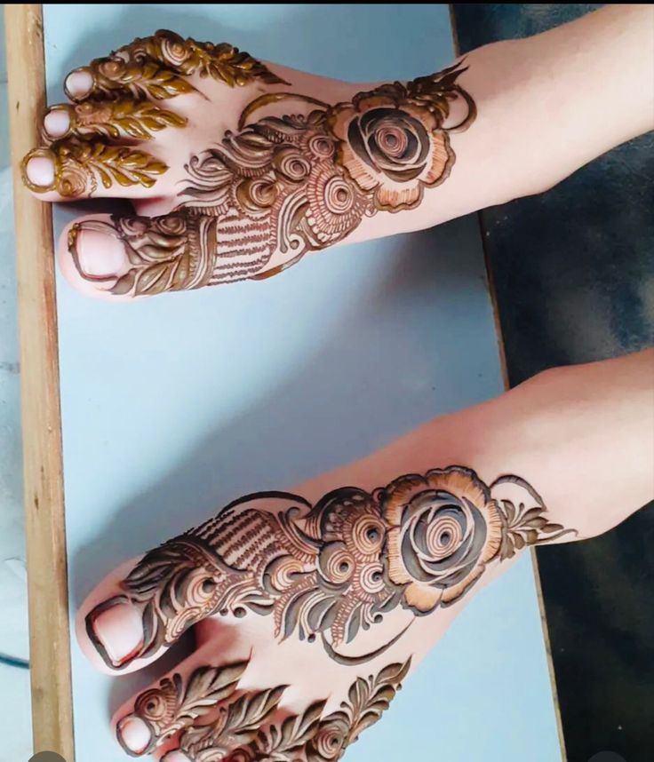 two hands with henna tattoos on them, one is showing off the intricate design