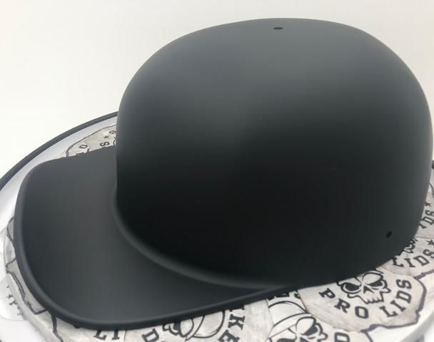 a black helmet sitting on top of a white and black plate with skulls around it