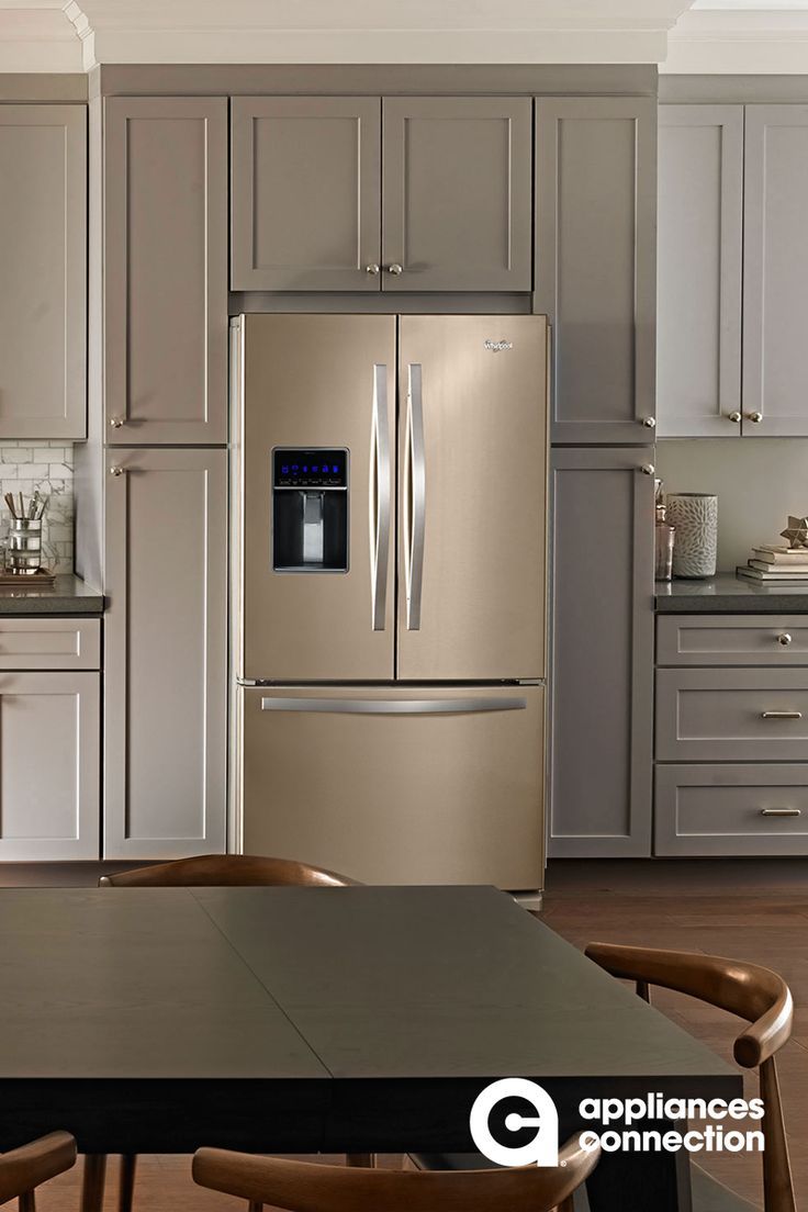 a modern kitchen with stainless steel appliances and wood table in front of the countertop