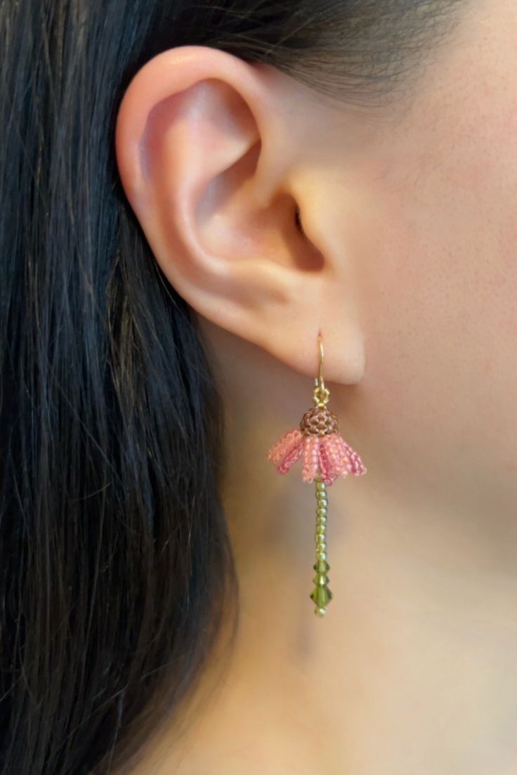 a close up of a person wearing some kind of earring with flowers on it