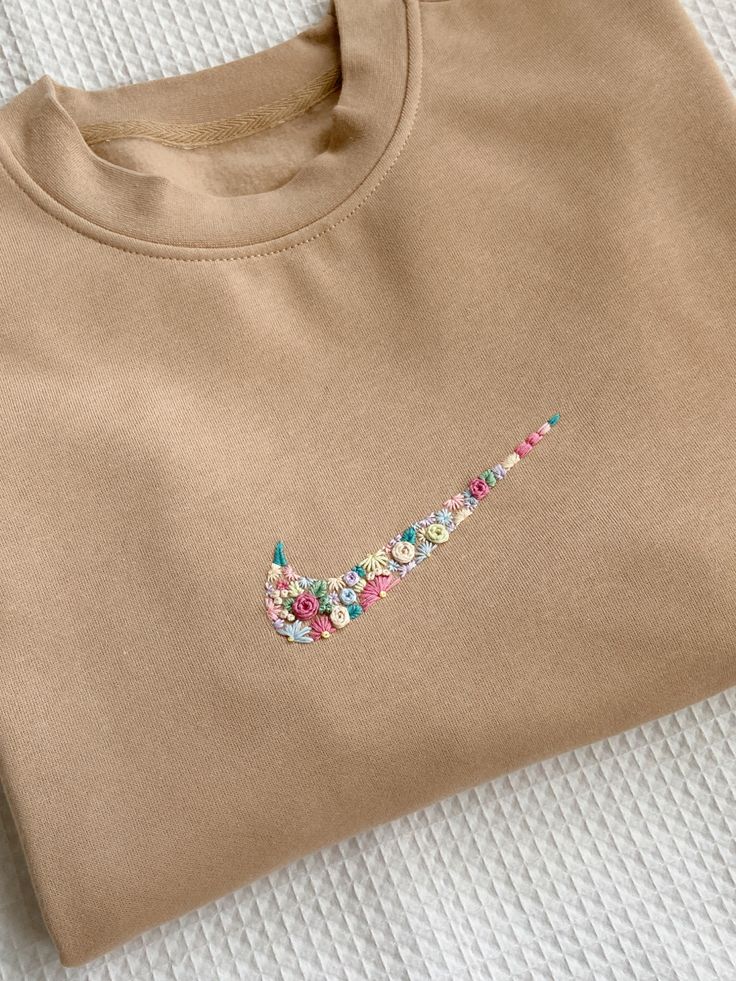 a t - shirt with the word'love'embroidered on it sitting on top of a bed