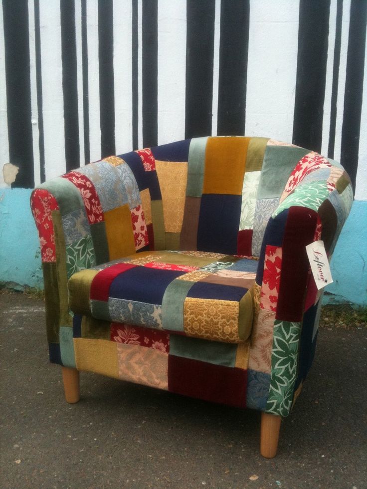 a patchwork chair sitting in front of a wall