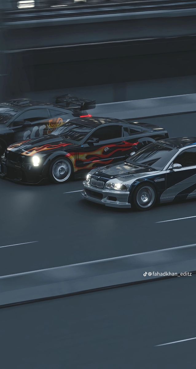 two cars driving on a race track with lights on each side and one car in the middle