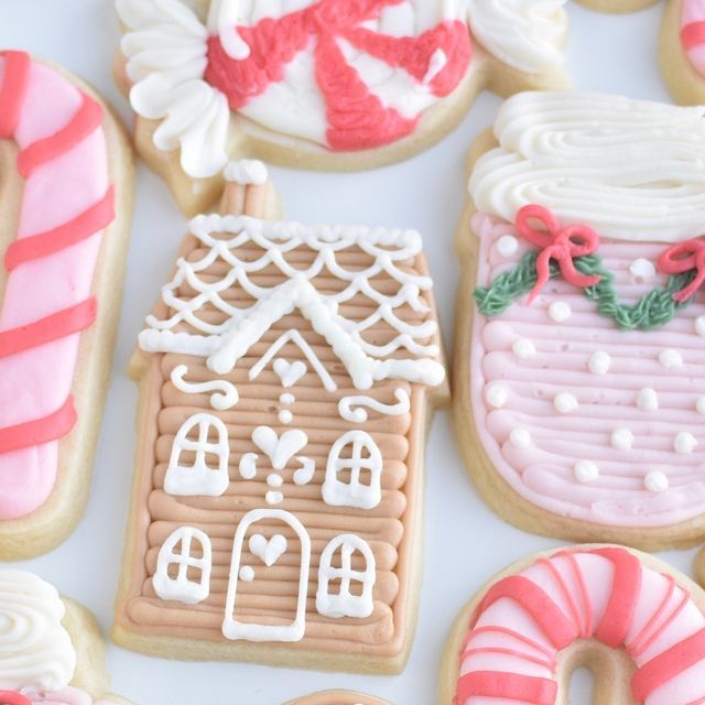 gingerbread cookies decorated with icing and candy canes on a white tablecloth