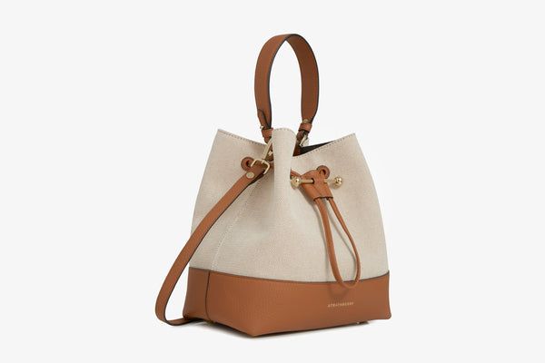 Our best-selling Lana Osette is reimagined in a larger silhouette, for those who need a little more room. A modern take on the classic bucket bag, the soft structure is handcrafted in Spain from buttery-soft pebble finished leather and features an elegant drawstring closure, complete with our signature music bar. This versatile, midi silhouette encourages everyday use and can be carried in hand by the leather top-handle, or styled as a crossbody bag with the detachable leather strap. Experience Chic Bucket Bag With Leather Trim, Versatile Bucket Bag In Textured Leather, Versatile Textured Leather Bucket Bag, Daily Use Bucket Hobo Bag With Leather Trim, Chic Satchel Bucket Bag With Leather Trim, Modern Bucket Shoulder Bag With Leather Trim, Modern Bucket Bag With Leather Trim For Shopping, Modern Leather Trim Bucket Bag For Shopping, Modern Leather Trim Bucket Shoulder Bag