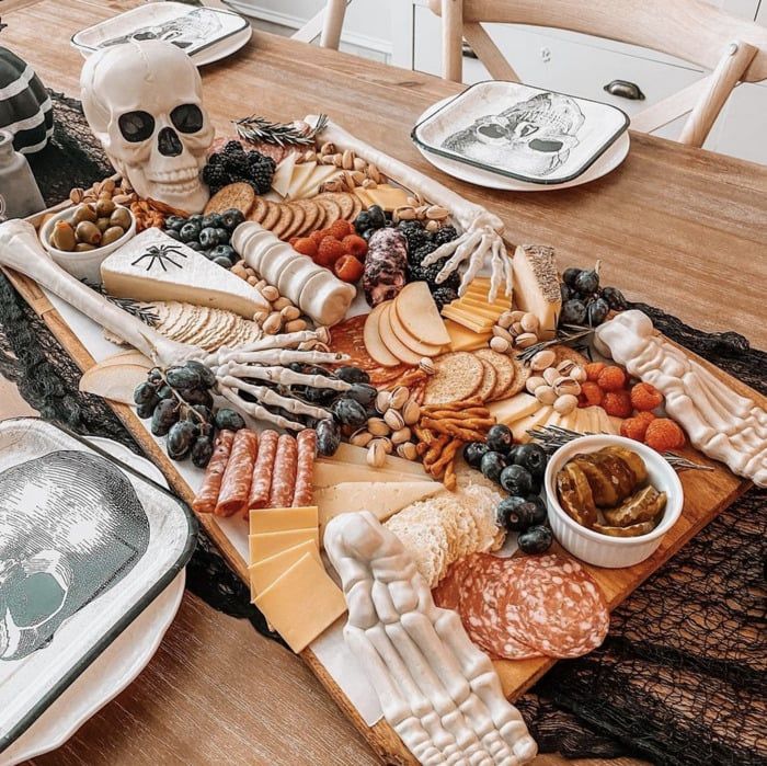 a wooden table topped with lots of different types of cheese and meats on top of it