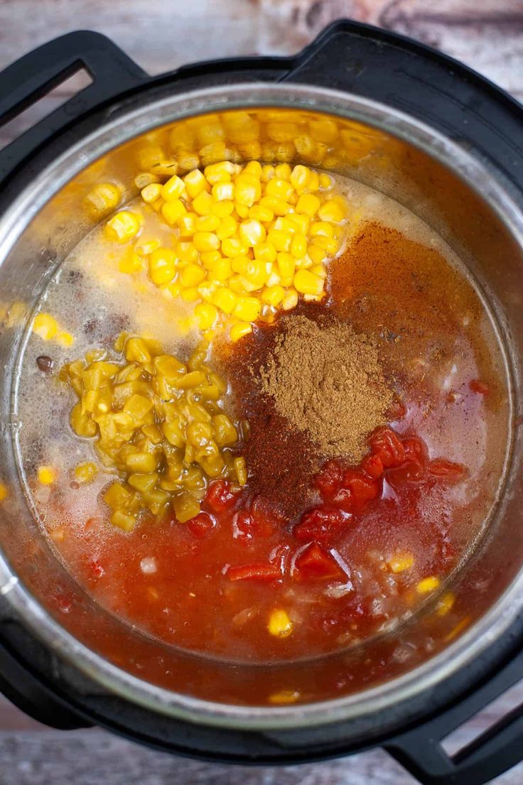 the ingredients are in the pot to make corn and tomato soup on the stove top