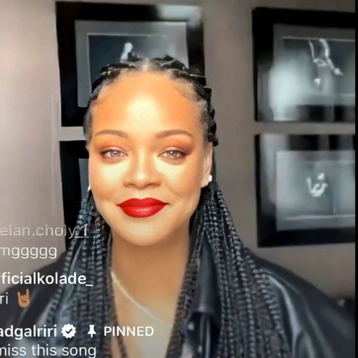 a woman with braids on her head and red lipstick in front of some pictures