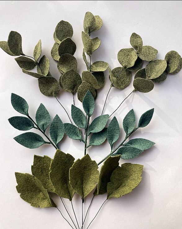 a bunch of green leaves on a white surface