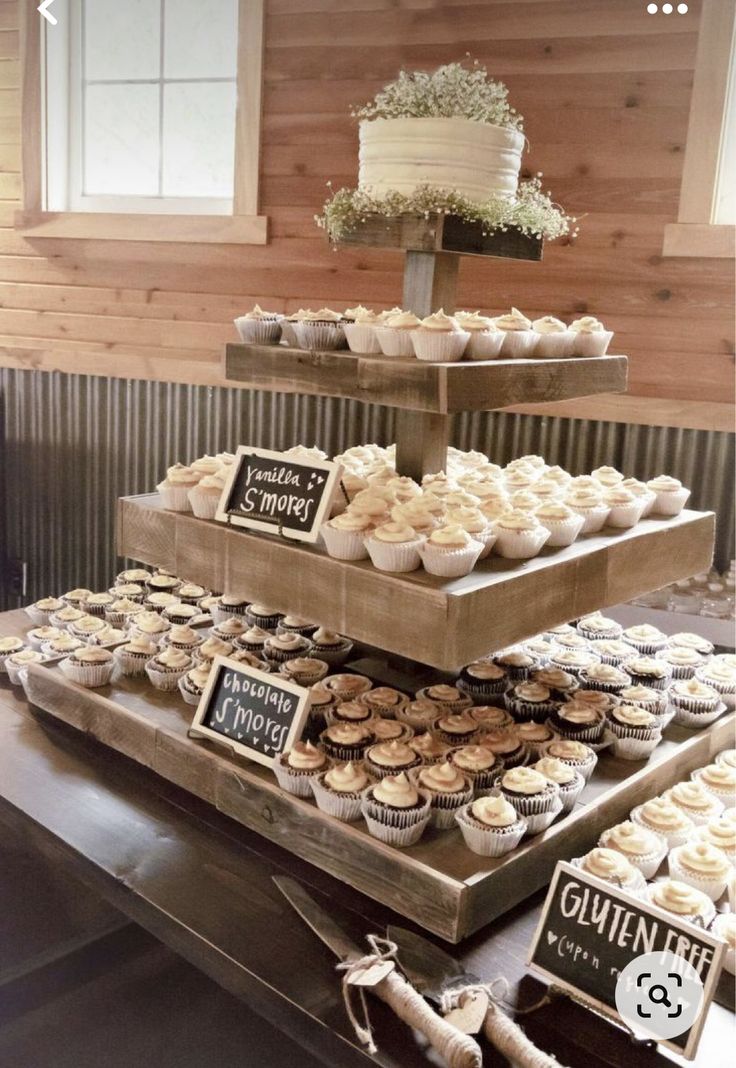 a table topped with three tiered trays filled with cupcakes