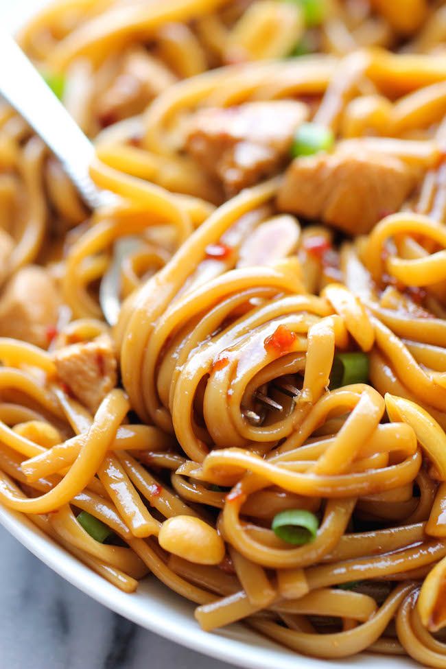 a close up of a plate of food with noodles and meat in sauce on it