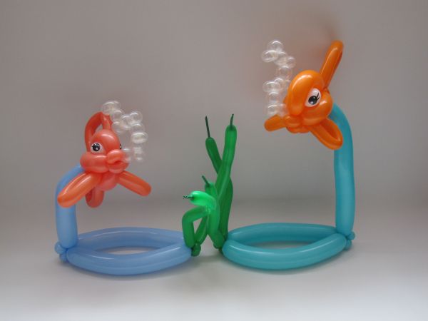 two inflatable blow up fish toys sitting next to each other on a white surface