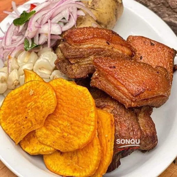 a white plate topped with meat and veggies on top of a wooden table