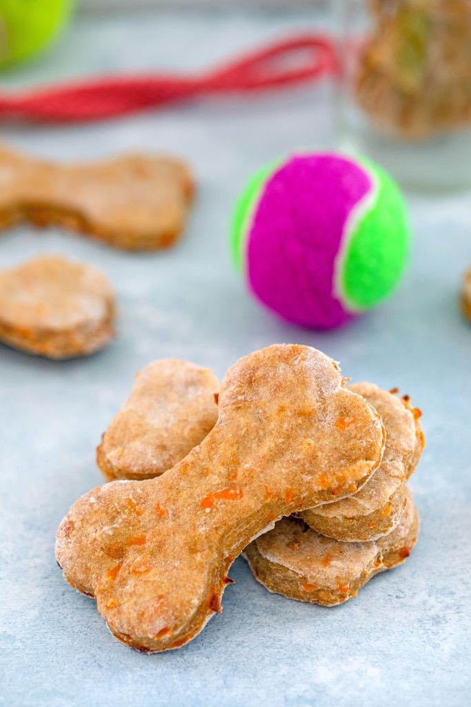 dog treats are stacked on top of each other with a ball in the back ground