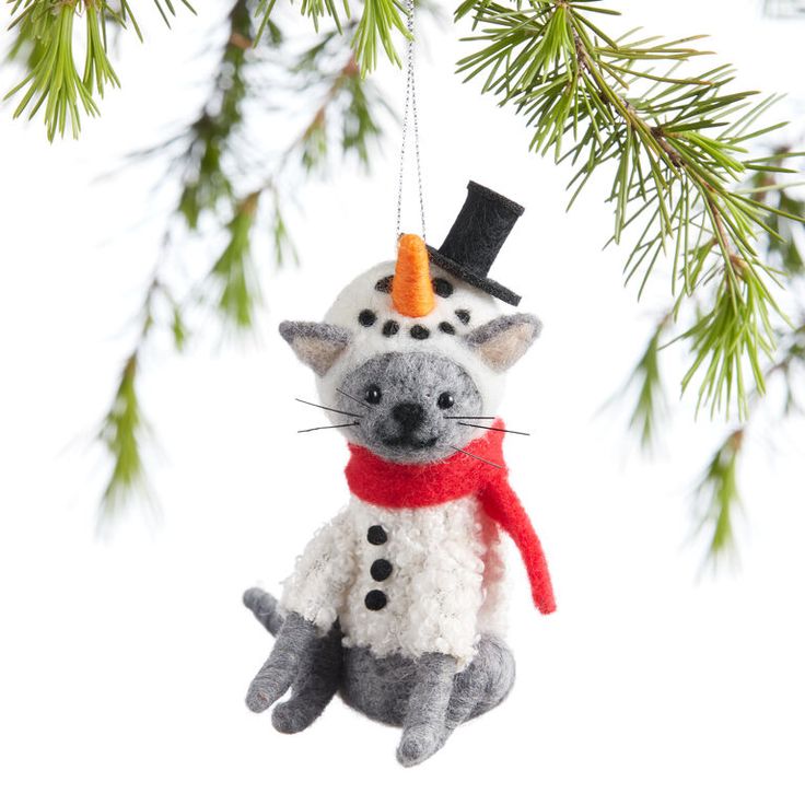 a christmas ornament hanging from a tree with a cat wearing a top hat and scarf