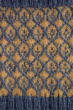 a blue and yellow knitted tie with an intricate design on it's side