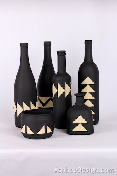 black and white vases with gold triangles on them are sitting next to each other