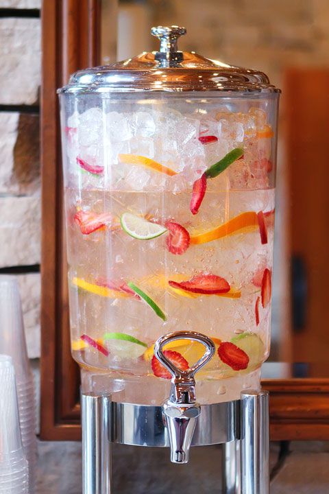 a beverage dispenser filled with lots of ice and colorful fruit on top