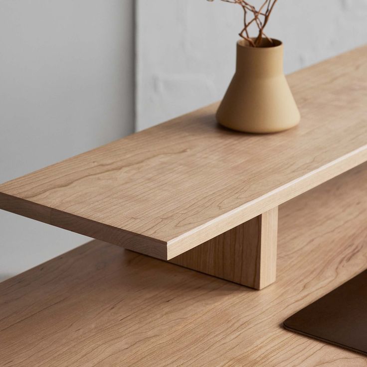 a vase with flowers sitting on top of a wooden table