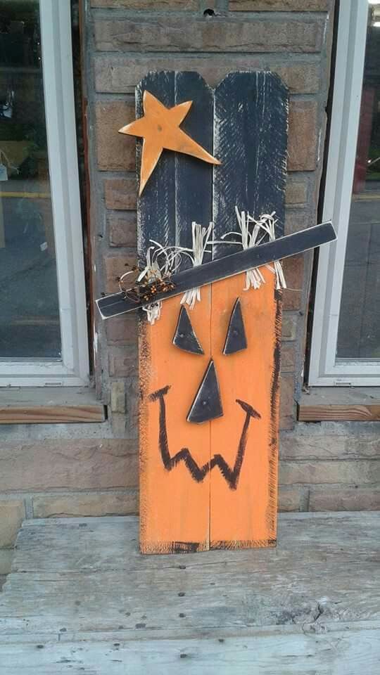 a halloween decoration made out of wood with a broom and stars on it's head