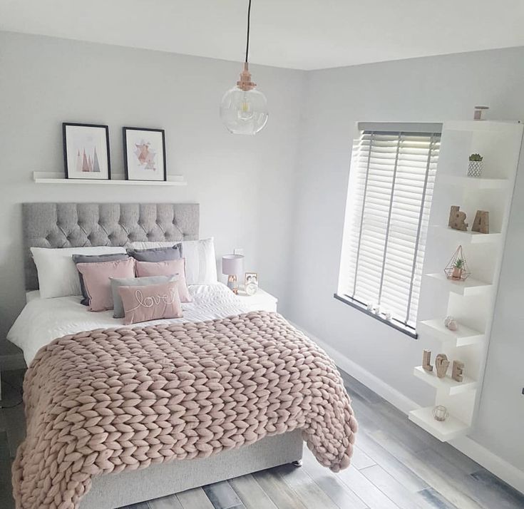 a bedroom with white walls and pink bedding