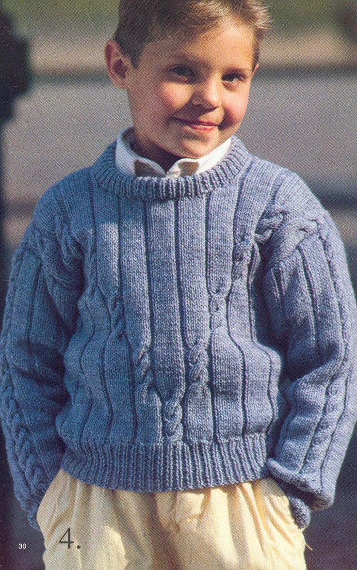 a young boy wearing a purple sweater and smiling at the camera with his hands in his pockets