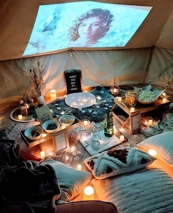 a room filled with candles and food in front of a projector screen