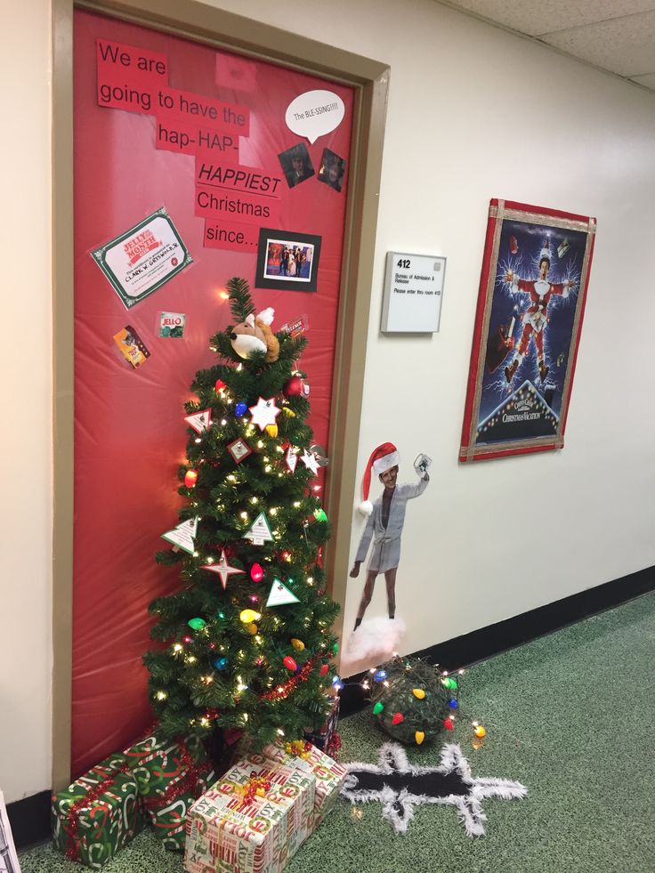 a decorated christmas tree in an office cubicle with presents on the floor and decorations around it