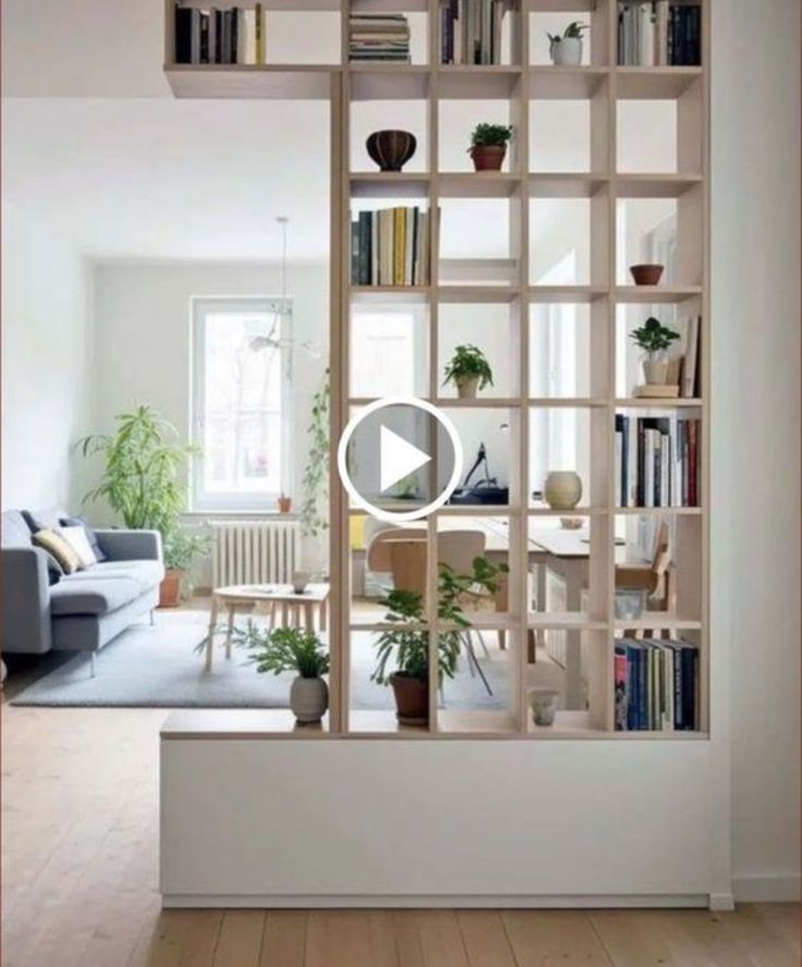 a living room filled with furniture and bookshelves next to a white couch in front of a window