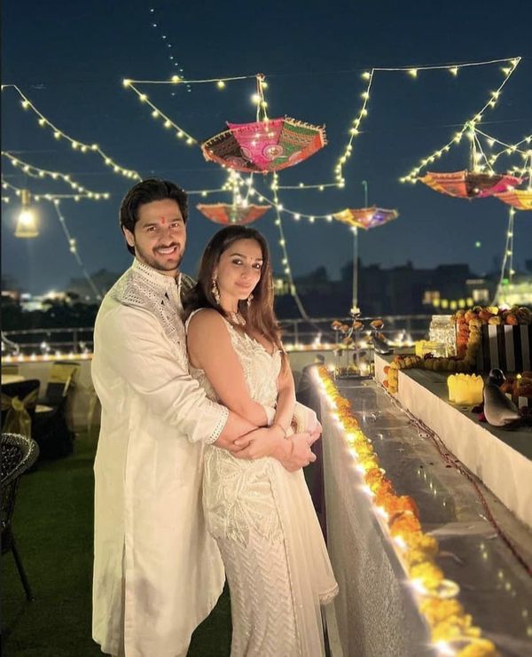 a man and woman standing next to each other in front of an outdoor bar at night