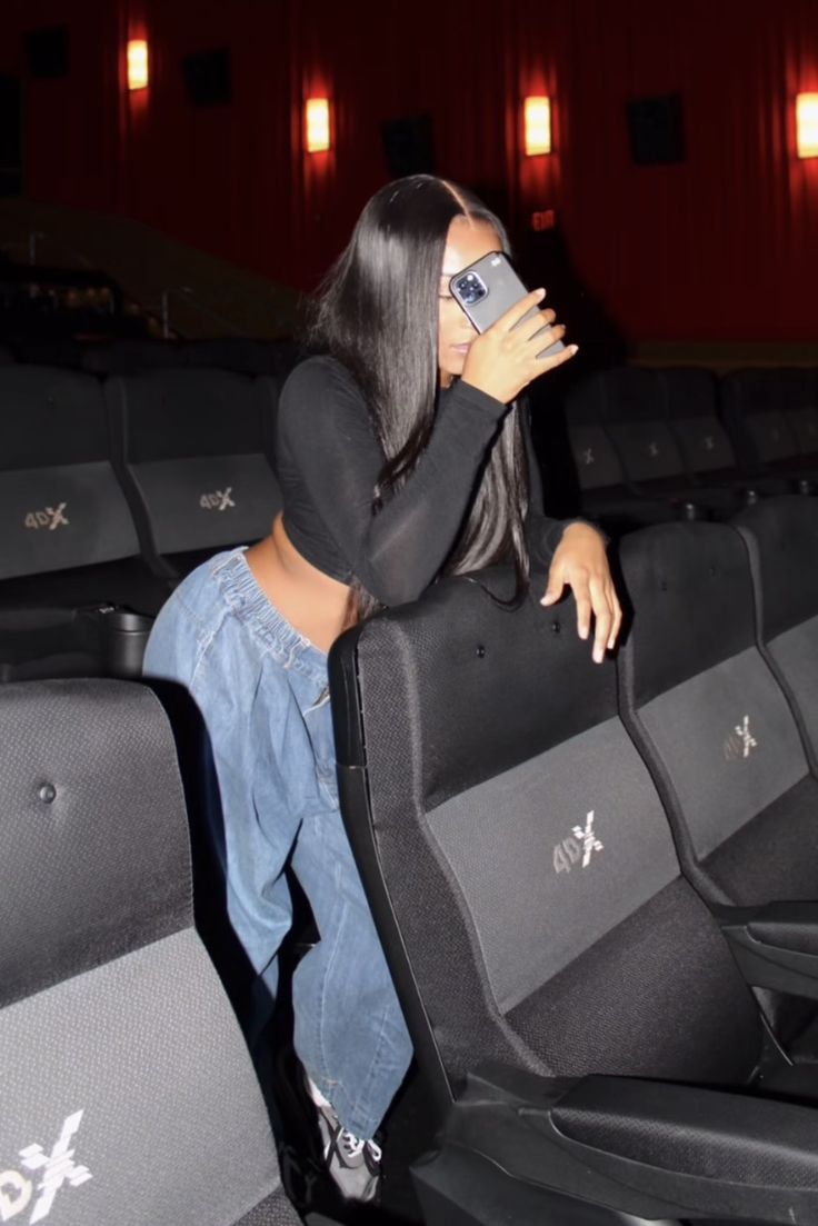 a woman is sitting in an empty theater