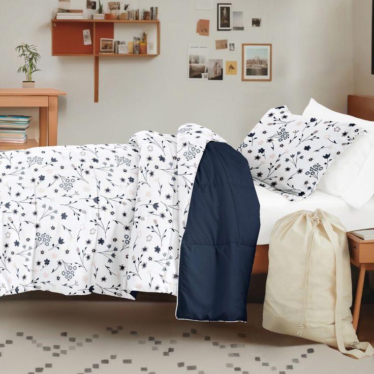 a bed sitting next to a wooden table with a bag on it's side