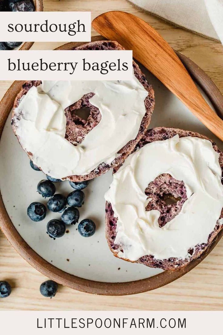 two blueberry bagels on a plate with cream cheese frosting and fresh blueberries