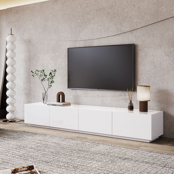 a flat screen tv sitting on top of a white entertainment center in a living room