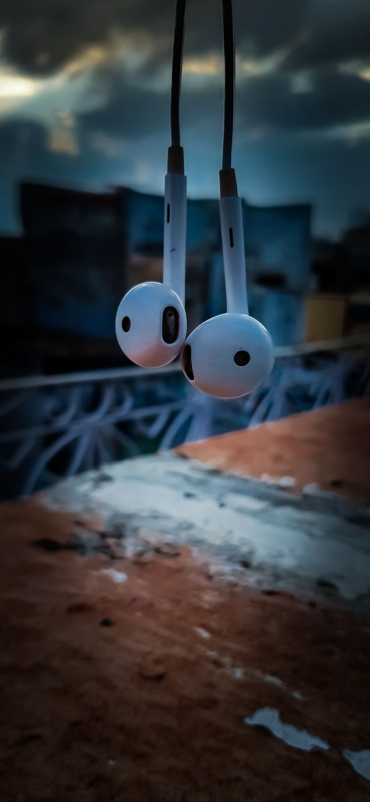 two earphones hanging from the ceiling in front of a cityscape at night