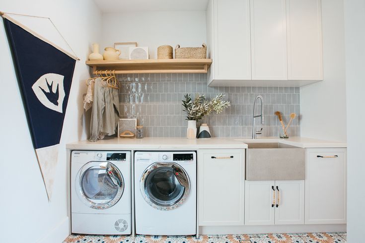 a washer and dryer sitting in a kitchen next to each other on top of a tiled floor