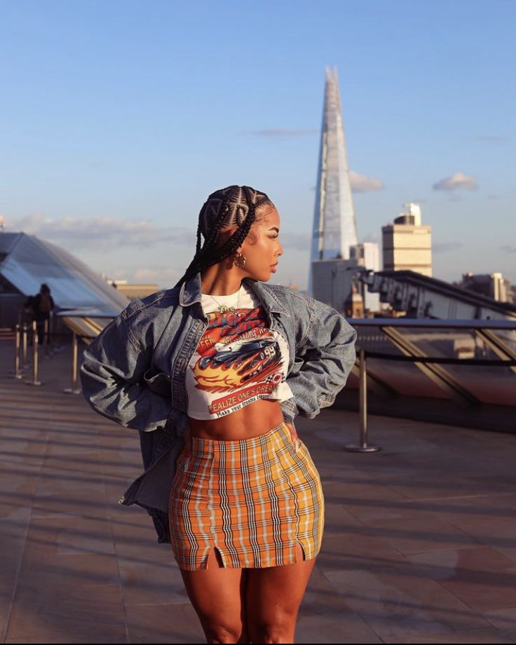 a woman standing on top of a roof with her hands in her pockets and looking off into the distance