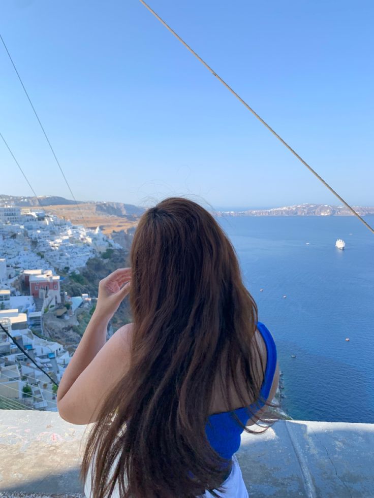 a woman is looking out over the water